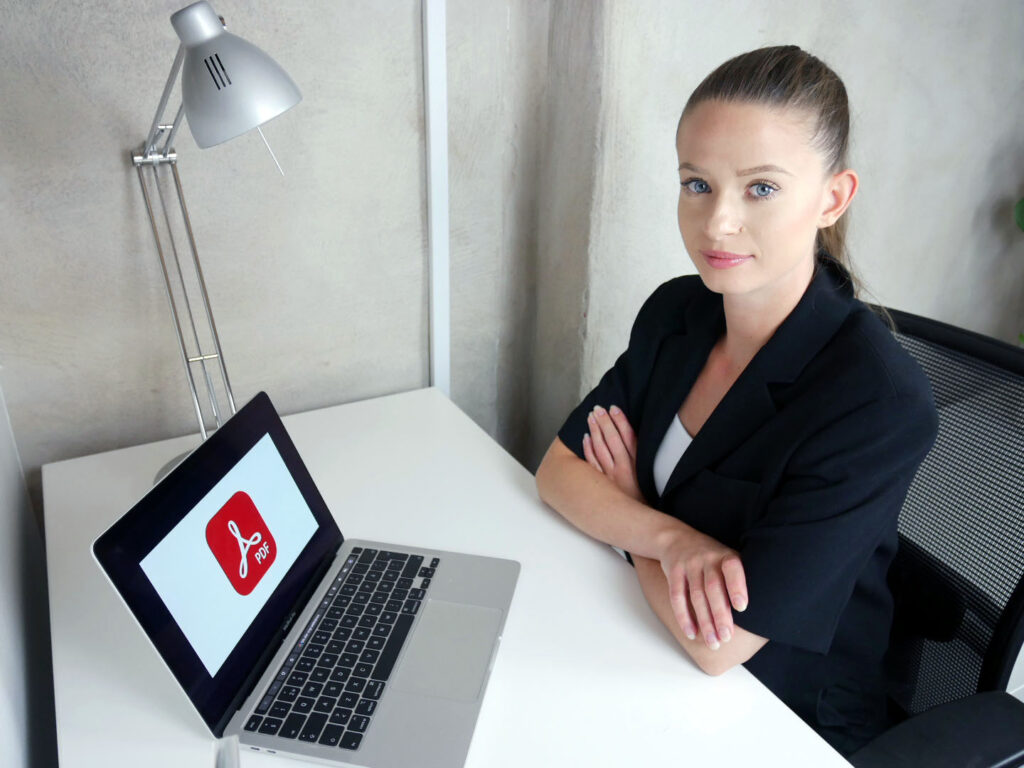 Erica på WCAG Networks kontor framför datorn med bild på PDF.